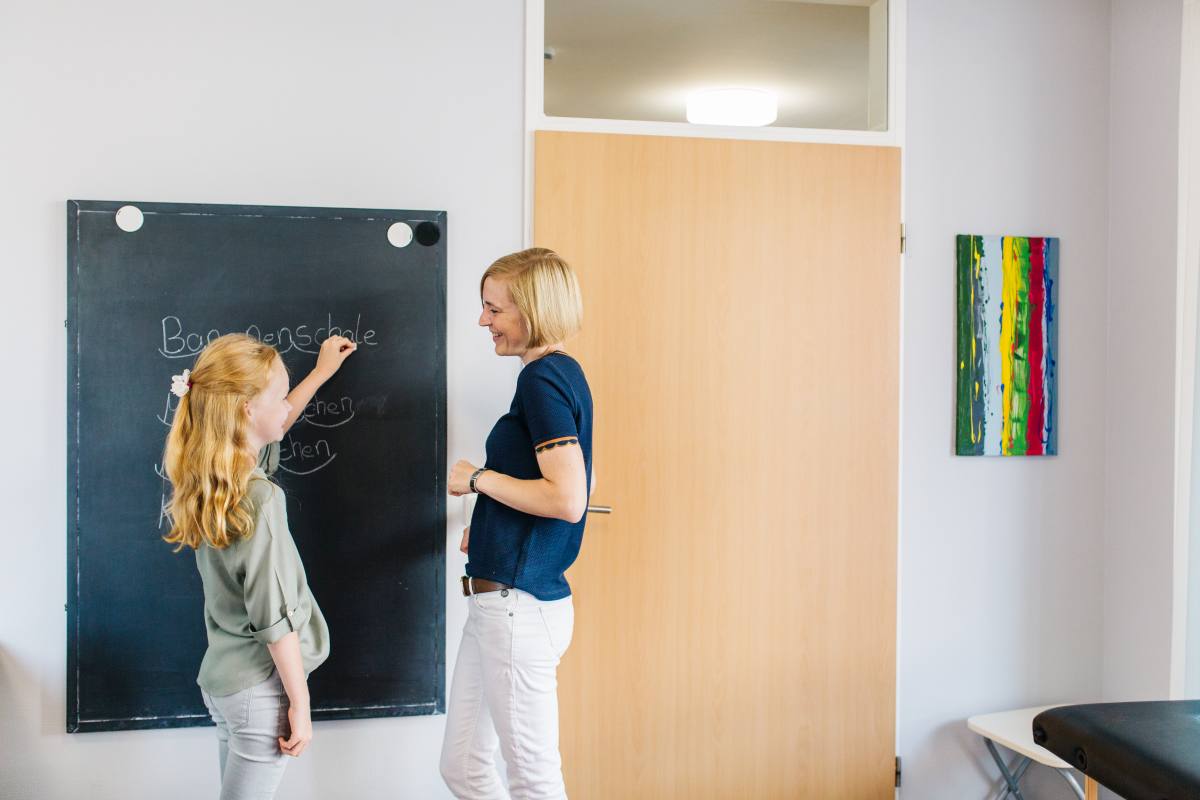 Schulkind übt Rechtschreibung an der Tafel mit einer Logopädin in der Praxis SprechWerk Bocholt